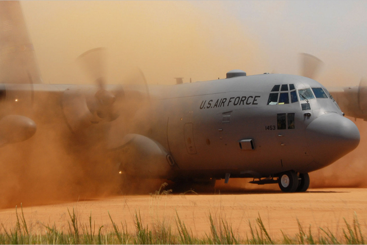 Lockheed Martin C-130J Hercules aircraft on a dusty airfield